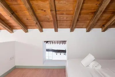 a bedroom with white walls and wooden ceilings at GuestReady - A brilliant stay near Ribeira in Porto