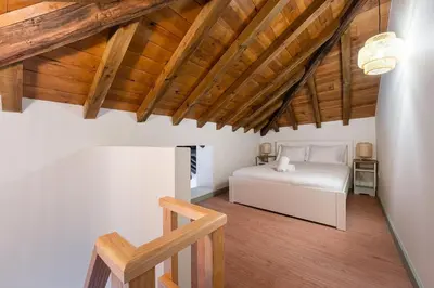 a bedroom with a white bed and wooden ceilings at GuestReady - A brilliant stay near Ribeira in Porto