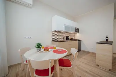 a white kitchen with a table and chairs in a room at Trindade Deluxe by Hosty in Porto