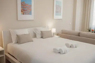 a bedroom with a white bed with towels on it at Trindade Deluxe by Hosty in Porto