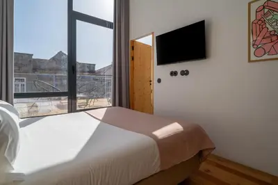 a bedroom with a bed and a large window at Limehome Porto Rua da Conceicao in Porto