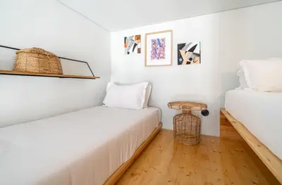 a bedroom with two beds and a table at Limehome Porto Rua da Conceicao in Porto