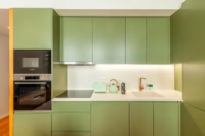 a green kitchen with a sink and a microwave at Savvy Signature Apartments in Porto