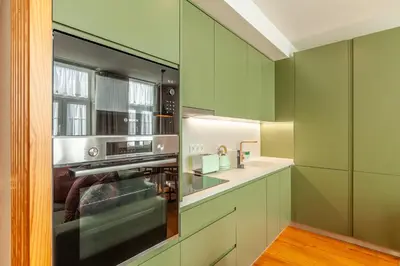 a kitchen with green cabinets and a stove at Savvy Signature Apartments in Porto