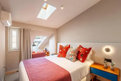 a bedroom with a bed with red pillows at Savvy Signature Apartments in Porto