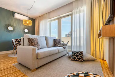 a living room with a couch and a large window at Stylish Poveiros Flat w Balcony by LovelyStay in Porto