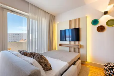 a bedroom with a bed and a large window at Stylish Poveiros Flat w Balcony by LovelyStay in Porto