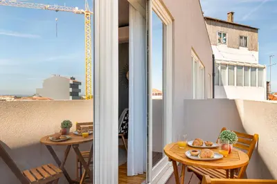 a balcony with a table with food on it at Stylish Poveiros Flat w Balcony by LovelyStay in Porto