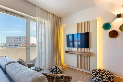 a living room with a couch and a tv at Stylish Poveiros Flat w Balcony by LovelyStay in Porto