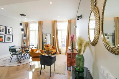 a living room with a large mirror and chairs at Saudade do Porto in Porto