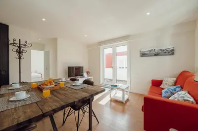 a living room with a wooden table and a red couch at Rooftop Panoramic Batalha- PORTO in Porto