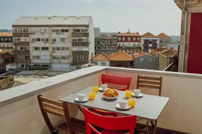 a table with food and orange juice on a balcony at Rooftop Panoramic Batalha- PORTO in Porto
