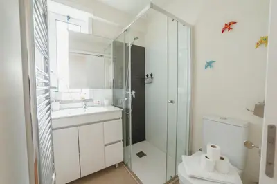 a white bathroom with a shower and a toilet at Rooftop Panoramic Batalha- PORTO in Porto