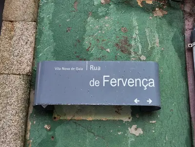 a sign on the side of a green wall at Fervença Apartments in Vila Nova de Gaia