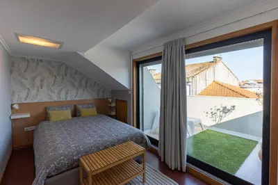 a bedroom with a bed and a large window at Top floor apartment with Sunny Balconies in Porto