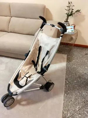 a folding baby stroller in front of a couch at Top floor apartment with Sunny Balconies in Porto