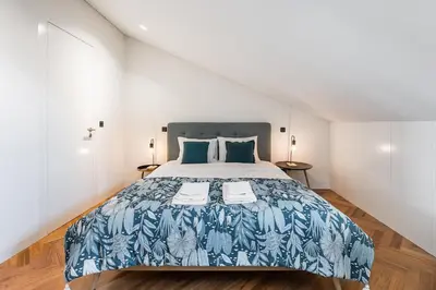 a bedroom with a bed with a blue and white bedspread at Elegant Duplex Apt in Downtown by Lisbeyond in Porto
