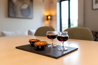 two glasses of wine and some food on a table at Elegant Duplex Apt in Downtown by Lisbeyond in Porto