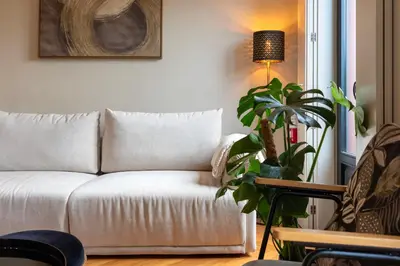 a white couch in a living room with a plant at Elegant Duplex Apt in Downtown by Lisbeyond in Porto