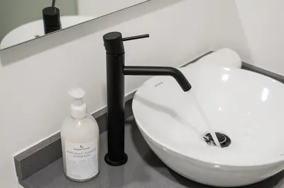 a bathroom with a toilet and a bottle of soap at GuestReady - A modern stay in Downtown in Porto