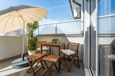 a balcony with a table and chairs and an umbrella at Nomad's Easy Stay - Studio Lounge Casa da Musica in Porto