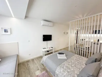 a living room with a bed and a tv at ROSARIO 1Dn by rosario inn porto in Porto