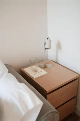 a bed with a wooden nightstand with a glass on it at Corujeira Apartments by MyALPlace in Porto