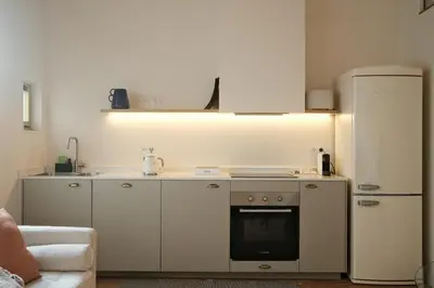 a kitchen with white cabinets and a refrigerator at Corujeira Apartments by MyALPlace in Porto
