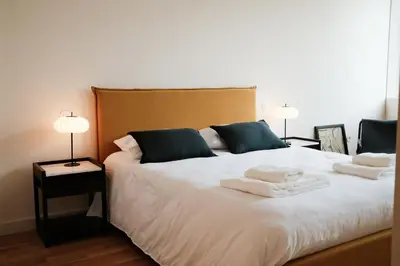 a bedroom with a large white bed with two lamps at Corujeira Apartments by MyALPlace in Porto