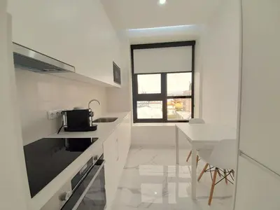 a white kitchen with a table and a window at VB Porto Studio II in Porto