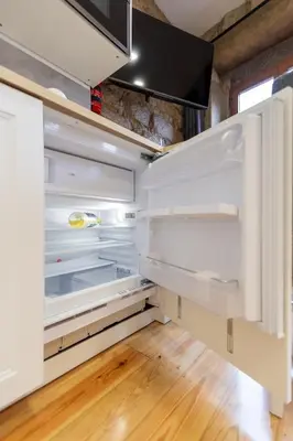 an empty refrigerator with its door open in a room at Charming Studio with Garden in Porto in Porto