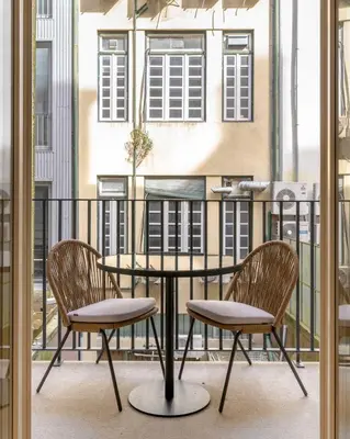 a table and two chairs on a balcony at Limehome Porto Rua 31 de Janeiro in Porto
