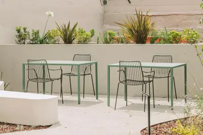 a green table and chairs in a patio with plants at Hotels 705 Porto Prime Home in Porto
