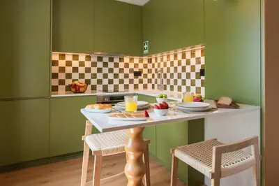 a kitchen and dining room with a white table and chairs at Hotels 705 Porto Prime Apartments in Porto