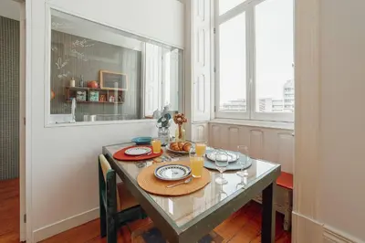 a dining room table with plates and glasses on it at Downtown Bolhão by Hosty in Porto