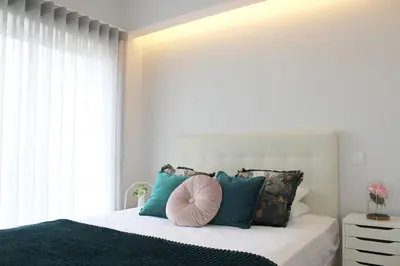 a bedroom with a large bed with blue pillows at Marquês City Center Flat in Porto