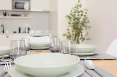 a table with white bowls and wine glasses on it at Liiiving in Porto - Luxury Design Apartments in Porto
