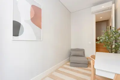 a living room with a chair and a picture on the wall at Liiiving in Porto - Luxury Design Apartments in Porto