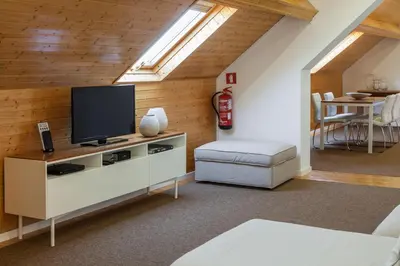 a living room with a flat screen tv on a wooden wall at BO - Fernandes Tomás in Porto