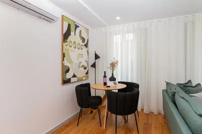 a living room with a table and chairs and a couch at GuestReady - Dream Vitoria Apartment in Porto