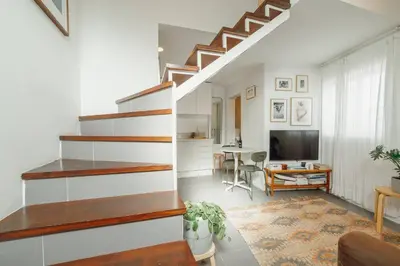 a living room with stairs and a dining room at Modern Studio by Hosty in Porto