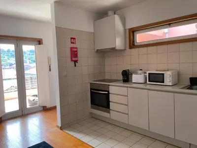 a kitchen with white cabinets and a microwave at Douro River Charming Flats in Porto