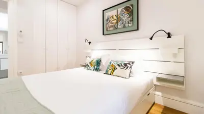 a white bedroom with a white bed with two pillows at Porto River Flat w/ Patio by LovelyStay in Porto