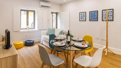 a living room with a dining room table and chairs at Porto River Flat w/ Patio by LovelyStay in Porto