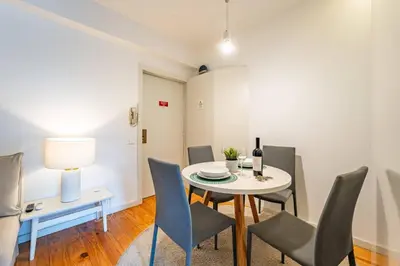 a bottle of wine and a wine glass on a counter at Brittos Lapa Apartment in Oporto City Center in Porto