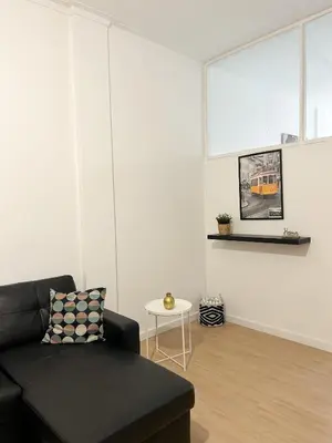 a living room with a black couch and a table at Oporto Central Flat - Downtown in Porto
