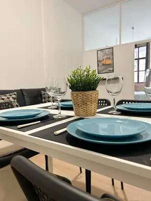 a dining table with blue plates and wine glasses at Oporto Central Flat - Downtown in Porto