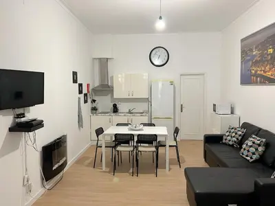 a living room with a couch and a table with chairs at Oporto Central Flat - Downtown in Porto