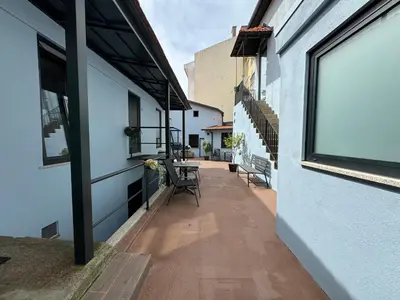 a walkway between two buildings with a table and chairs at Casas da Corujeira 2 in Porto