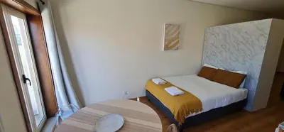 a small bedroom with a bed and a table at Tomas FLAT Front in Porto